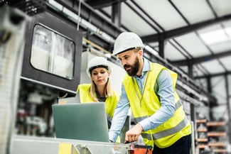 Man and woman engineer with a laptop in a factory