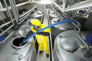 Technician Transferring Chemicals in an Industrial Facility